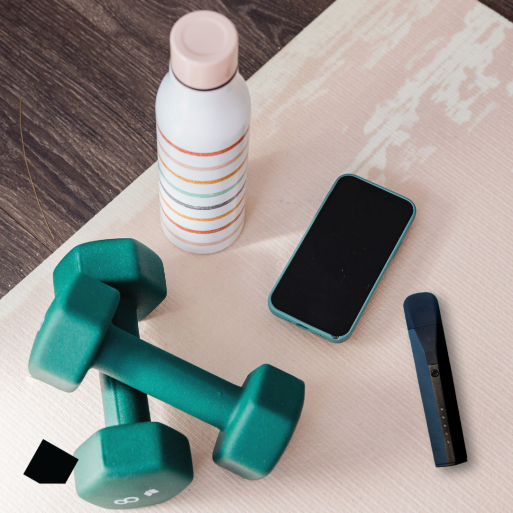 Gym setting with dumbells, cellphone, waterbottle and Mixturus Herbal Vaporizer